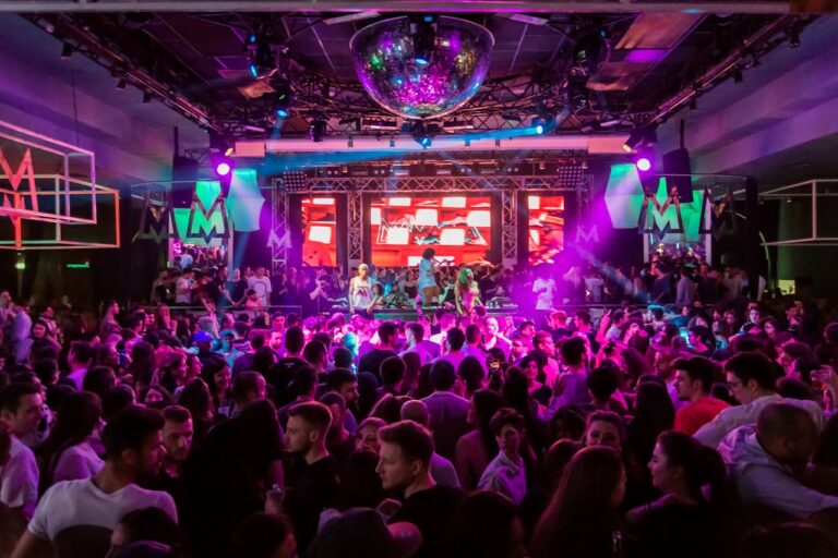Crowded nightclub in Phuket with vibrant lights and DJ on stage