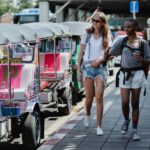 Two tourists walking by tuk-tuks in Thailand – Thailand India Holidays