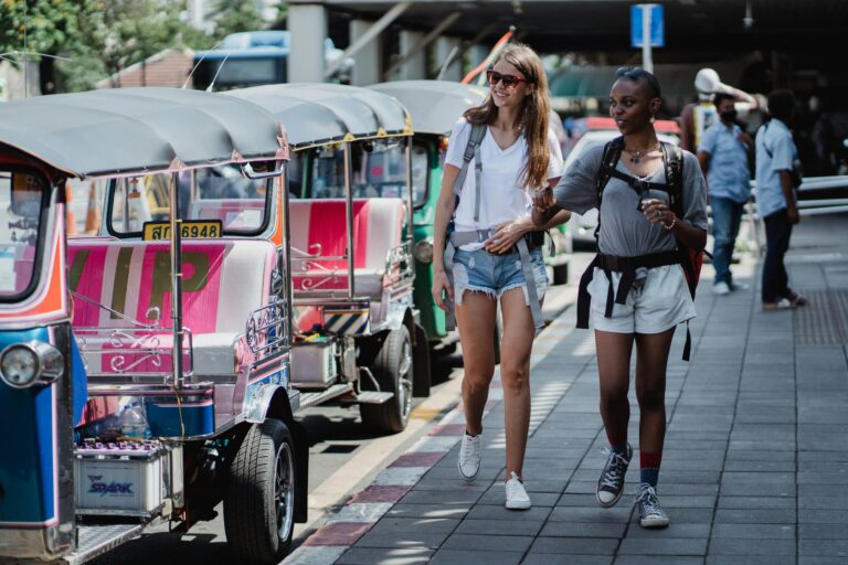 Two tourists walking by tuk-tuks in Thailand – Thailand India Holidays